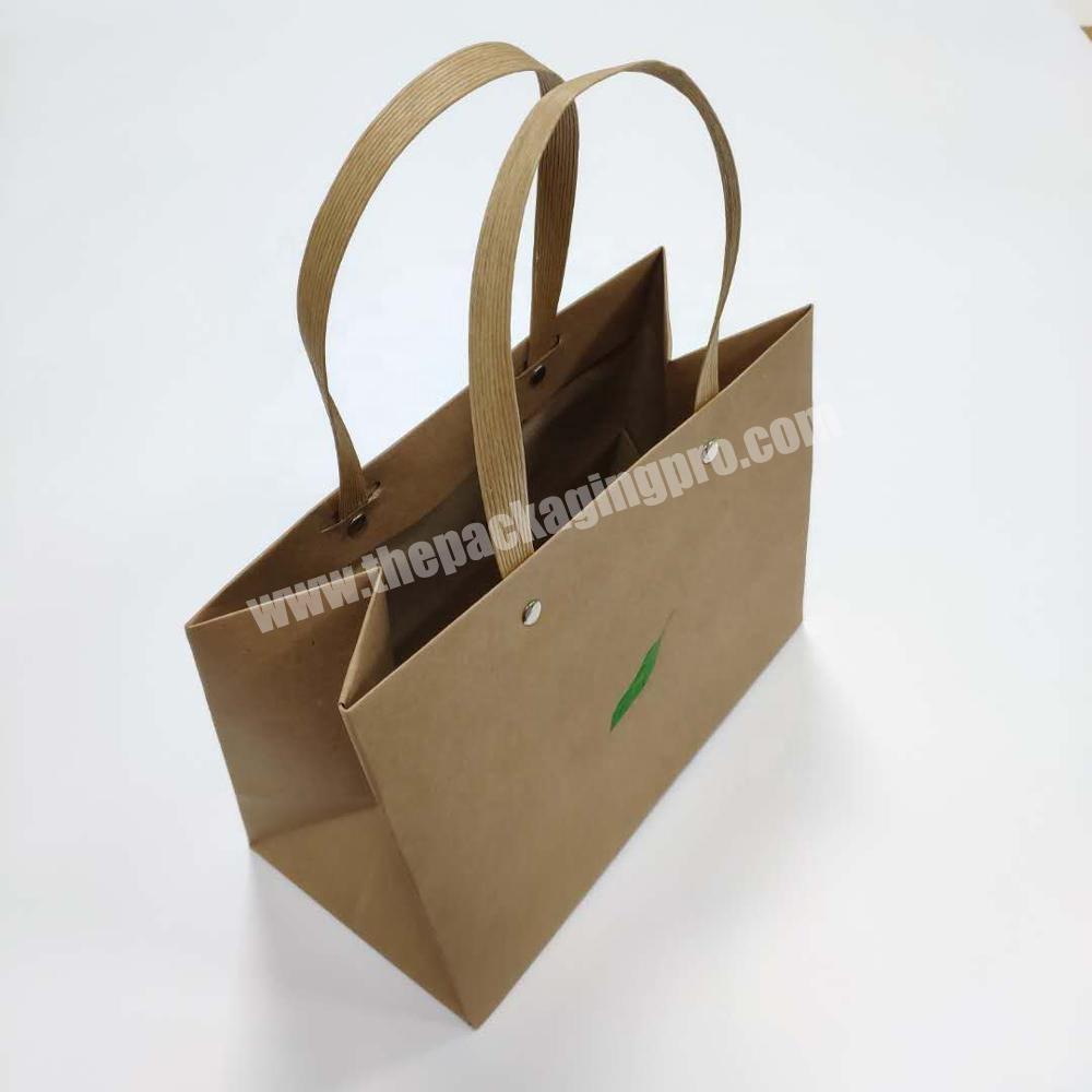 Brown kraft paper bag with green foil logo and paper cord handle