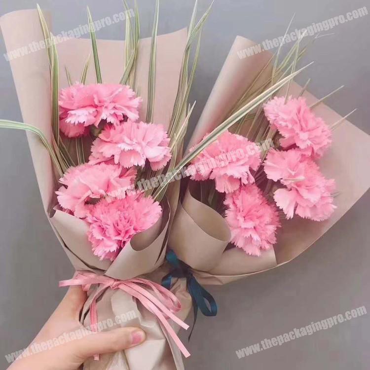 Premium Photo  Florist cuts wrapping paper for a bouquet of flowers.